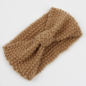 Detailed close-up of camel corn-knit headband with twist bow knot and chunky texture