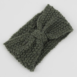 Detail of olive green knit headband featuring thick corn kernel texture and bow knot design