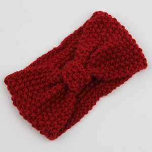 Detailed texture of dark red chunky knit headband with a stylish twist knot design