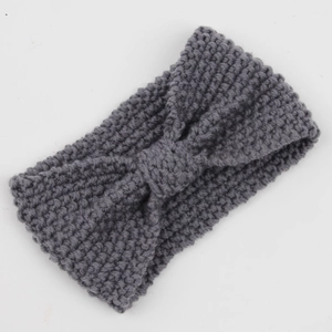 Close-up of a grey knitted headband with a stylish bohemian knot and bow design