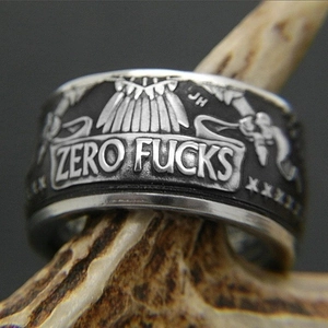 Breiter Punk-Ring aus Legierung mit Zero Fucks Gravur auf rustikalem Geweih-Ständer
