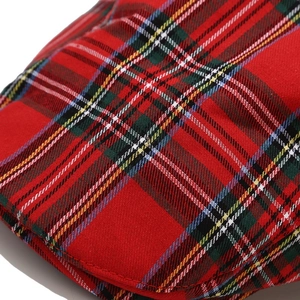 Detailed macro view of red tartan pattern fabric and stitching on a classic beret hat