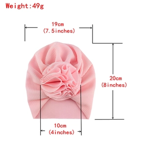 Pink waffle knit baby turban hat with large flower decoration and size measurements