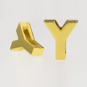 Macro detail of 3D gold metal alphabet Y charm for DIY keychains and jewelry making