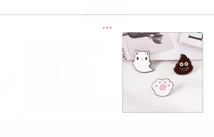 Detail of enamel pin set featuring cute cat paw, ghost, and poop emoji designs in zinc alloy