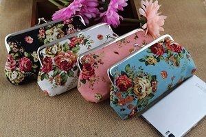 Close-up of vintage floral canvas purses with metal clasps and rose patterns on burlap