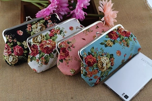 Floral cotton canvas wallet with metal clasp closure shown next to a smartphone for scale