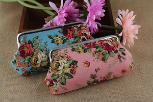 Close-up of floral canvas wallets with vintage rose patterns and metal clasps