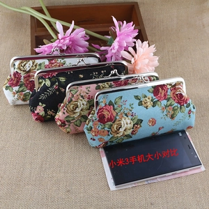 Detailed view of vintage floral fabric purses with retro metal clasp and rose print