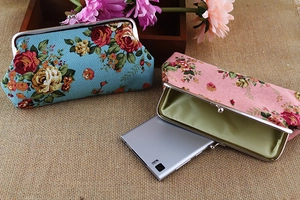 Floral canvas pouch showing storage capacity for a smartphone with metal clasp