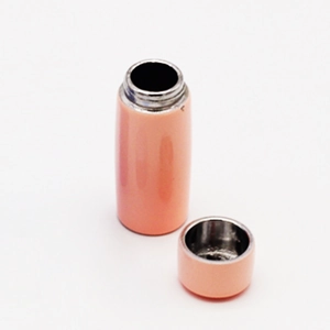 Close-up of a miniature pink dollhouse thermos with an openable lid and metal rim detail