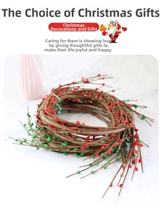 Détail d'une base de couronne de Noël en rotin avec des baies rouges et vertes brillantes