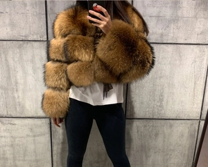 Detail of cropped faux fur jacket in tan brown with segmented tiered design and high collar