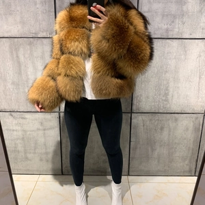 Detail of a fluffy faux fur short jacket in tan color with thick plush texture