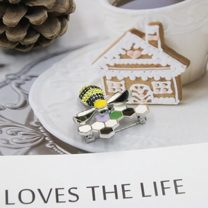 Detail view of crystal bee and honeycomb brooch with colorful enamel and rhinestone inlay