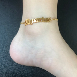 Macro detail of a 18K gold plated Aquarius zodiac anklet worn on woman ankle