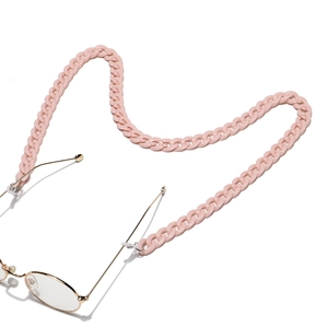 Dettaglio catena per occhiali in acrilico rosa fissata a montatura dorata elegante