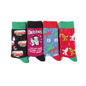 Flat lay of four colorful Christmas cotton socks featuring unique cartoon holiday patterns
