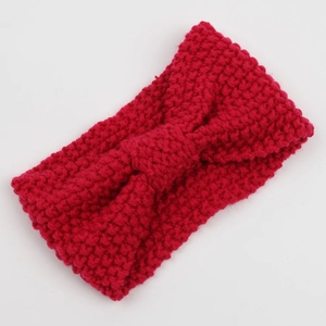 Detail of red corn kernel knit headband featuring a central knot and textured pattern