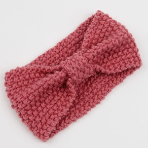 Detail of rose pink chunky knit headband featuring thick texture and twisted bow knot