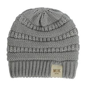 Close-up of grey knitted winter hat showing detailed texture and MOK KIDS label
