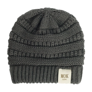 Detailed close-up of dark grey knitted kids beanie featuring a MOK KIDS woven label