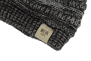 Close-up of knit texture and MOK KIDS label on brown and white winter beanie