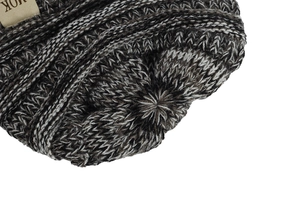 Detail shot of heavy-knit mixed color baby hat showing top closure and soft texture