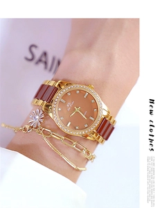Detail of elegant coffee-colored ceramic watch and gold daisy bracelet on female wrist