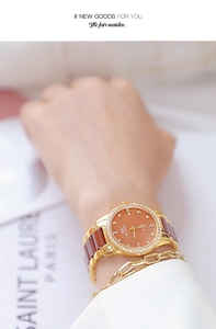 Detailed close-up of a luxury women's watch with ceramic band and sparkling rhinestones