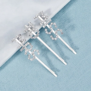 Close-up of three silver rhinestone hair clips with MISS, MS and MRS letter designs