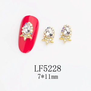 Detail of 7x11mm drop-shaped glass nail crystal with gold base and iridescent accents