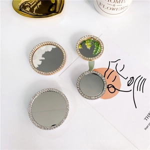 Detail of round rhinestone mirror phone grips in silver and rose gold finishes