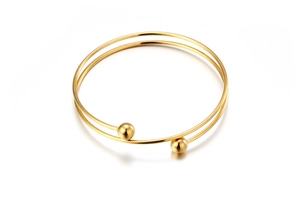 Detail of minimalist double-layer gold stainless steel bangle with polished metal beads