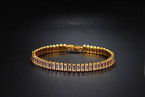 Close-up of hip hop gold Cuban chain with rectangular cut crystal inlay on black background