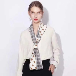 Detail of silk-like scarf with split design of grey plaid and brown heart patterns