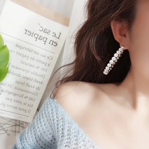 Close-up of elegant long drop earrings featuring a line of sparkling round cubic zirconia