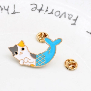 Close-up of cat-mermaid enamel pin with scales and double golden butterfly clasps