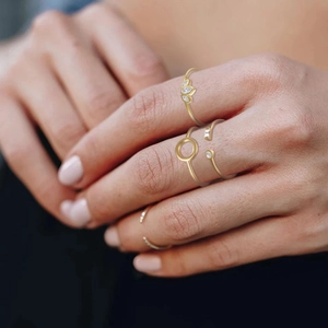 Close-up of gold-plated minimalist stackable rings with sparkling zircon inlay details