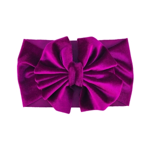 Detail view of premium magenta velvet bow headband with soft textured elastic fabric