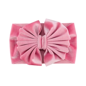 Detailed view of large plush velvet bow headband for infants with pleated texture in rose pink