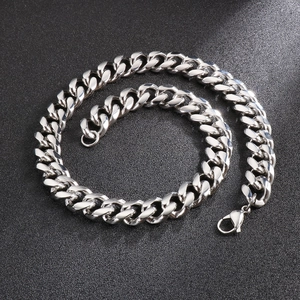 Close-up of a silver Cuban link chain with a secure lobster clasp on a dark surface