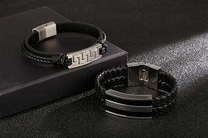 Macro detail of men's braided leather bracelet with stainless steel Greek key clasp