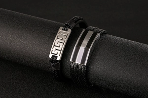 Macro detail of multi-layer black braided leather bracelets with metallic alloy clasps