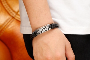 Detailed shot of men's braided leather bracelet with silver Greek meander metal plate