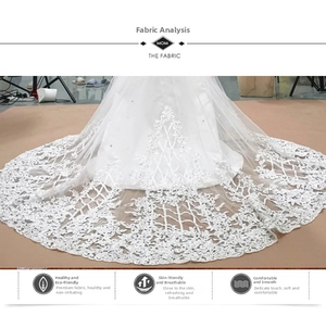 Vue détaillée des broderies en dentelle florale blanche et paillettes sur une traîne de mariée