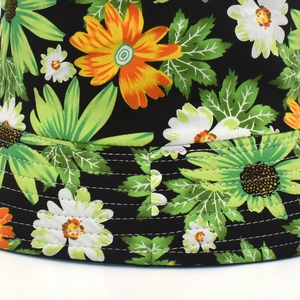 Unisex black bucket hat featuring vibrant floral daisy print and white stitched brim
