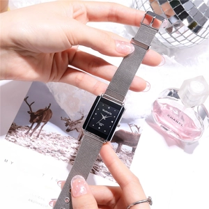Detail shot of rectangular black dial quartz watch with silver mesh strap and hour markers