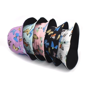 Five butterfly print bucket hats in purple, blue, pink, black, and white colors