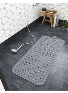 Dettaglio del tappetino antiscivolo in PVC grigio con fori di drenaggio nella doccia